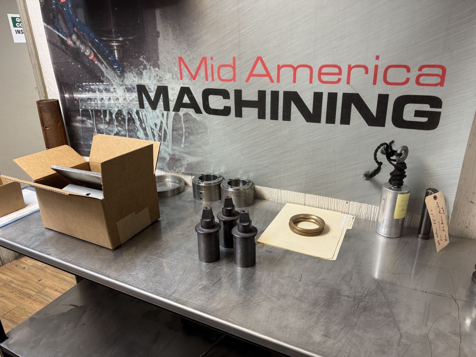 Mid America Machining shop interior with finished parts staged on the bench