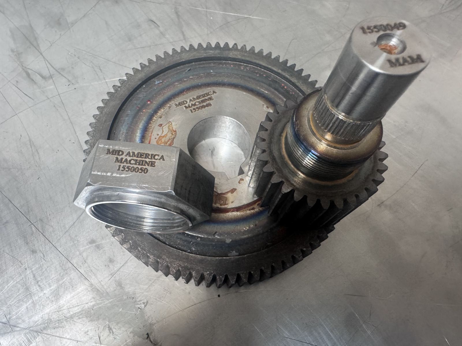 MAM-branded gear and splined shaft assembly with heat-tempering marks