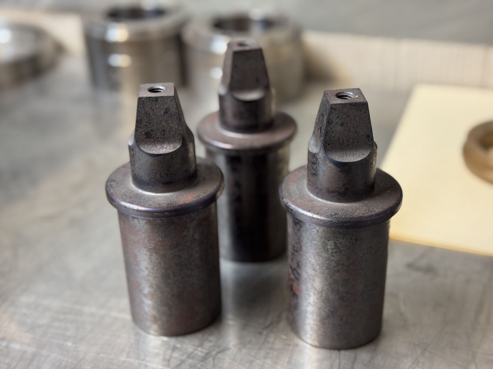 Three matched heat-treated turned parts with hex-broached pins